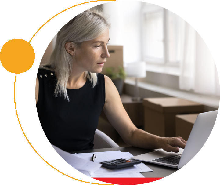 A woman sitting at her desk using a laptop.